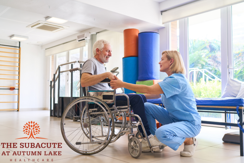 Nurse assisting a senior man in a wheelchair at an assisted living gym.