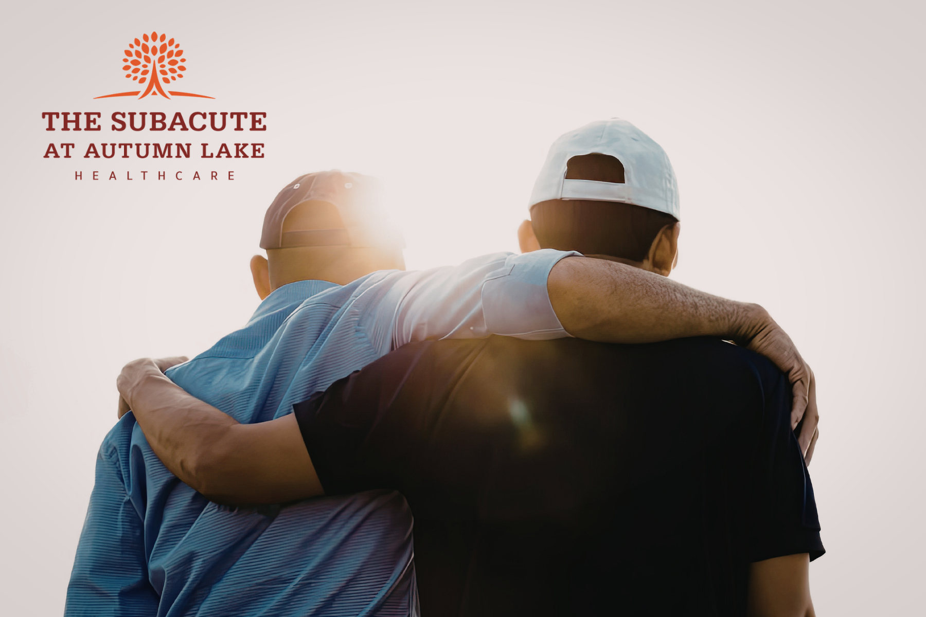 Two men at The Subacute at Autumn Lake stand with their arms around each other's shoulders at sunset.